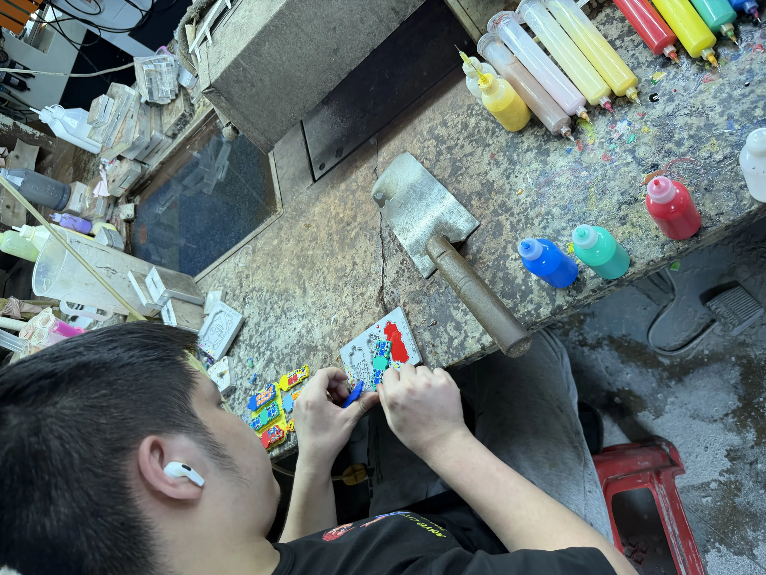 Worker hand-painting a custom PVC badge sample