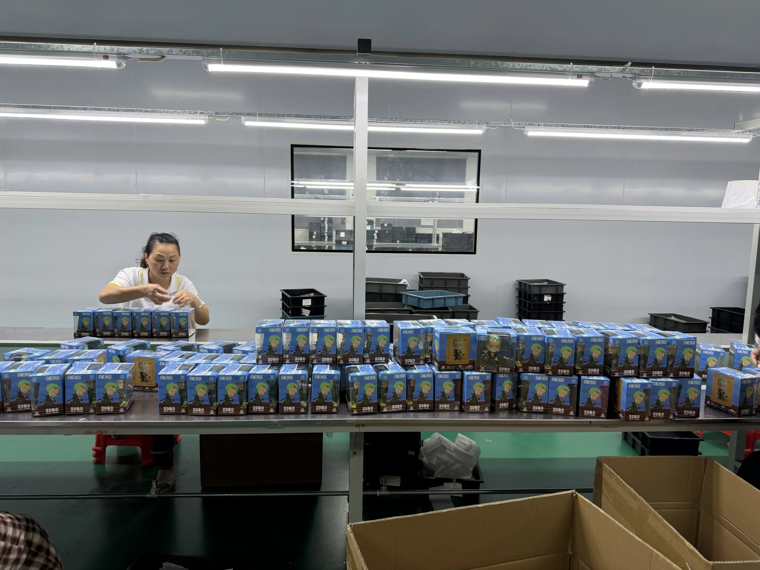Worker packing boxed custom PVC figurines