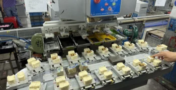 Pad printing machine applying color to custom PVC toy parts